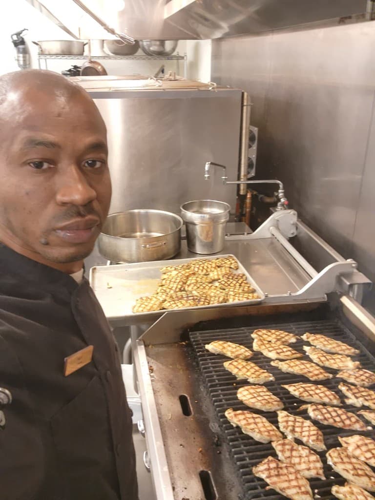 Chef Brian grilling chicken on a commercial grill